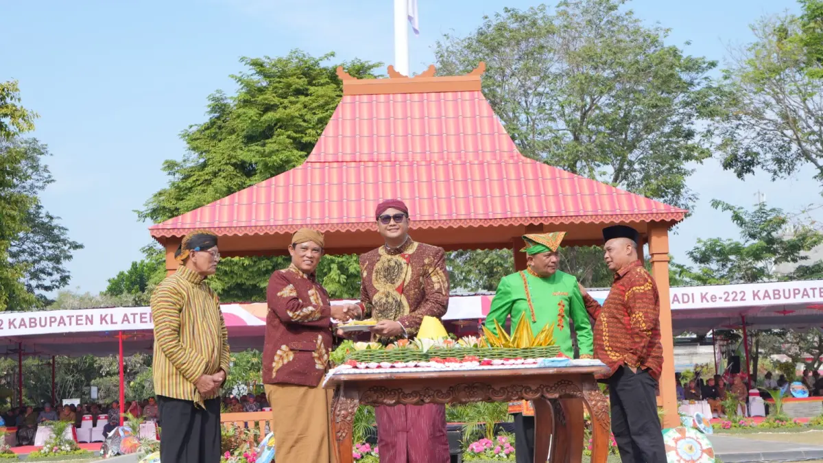 Bupati Klaten Hamenang Wajar Ismoyo saat melakukan pemotongan tumpeng dalam peringatan Hari Jadi ke-222 Klaten untuk diberikan bupati dan wakil bupati terdahulu, Selasa (28/7/2026). (DOK.DISKOMINFO KLATEN)