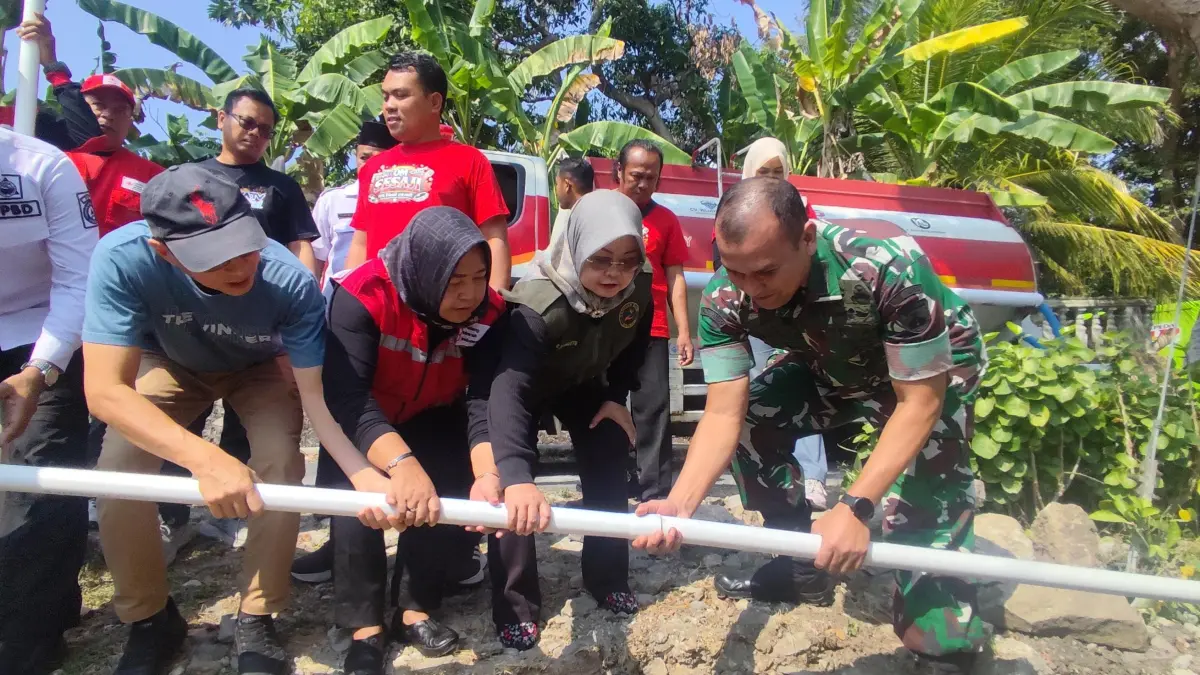 Dandim 0726/Sukoharjo Letkol Inf. Reza Sahputra dan Ketua PMI Sukoharjo dr. Kunari Mahanani pasang bantuan pipanisasi saat dropping air bersih di Kecamatan Weru, Rabu (29/7). (DOK. PMI SUKOHARJO)