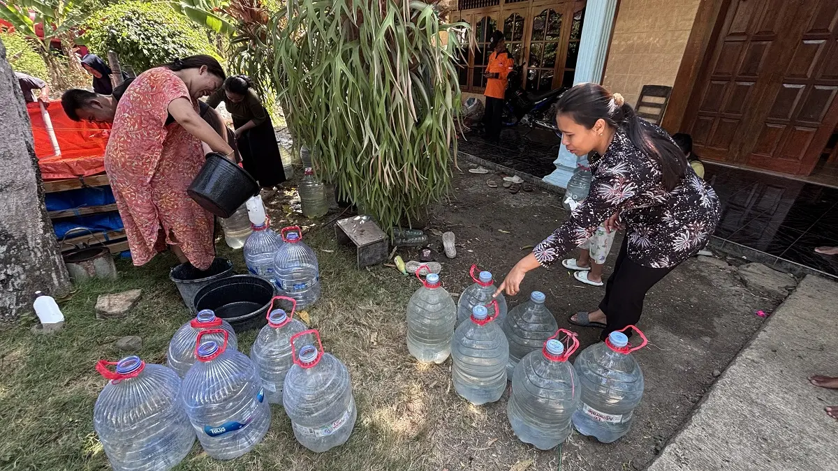 Warga Desa Bercak, Wonosamodro, Boyolali menuangkan air bersih bantuan BPBD Boyolali, Rabu (5/8/2026). (ARIEF BUDIMAN/RADAR SOLO)