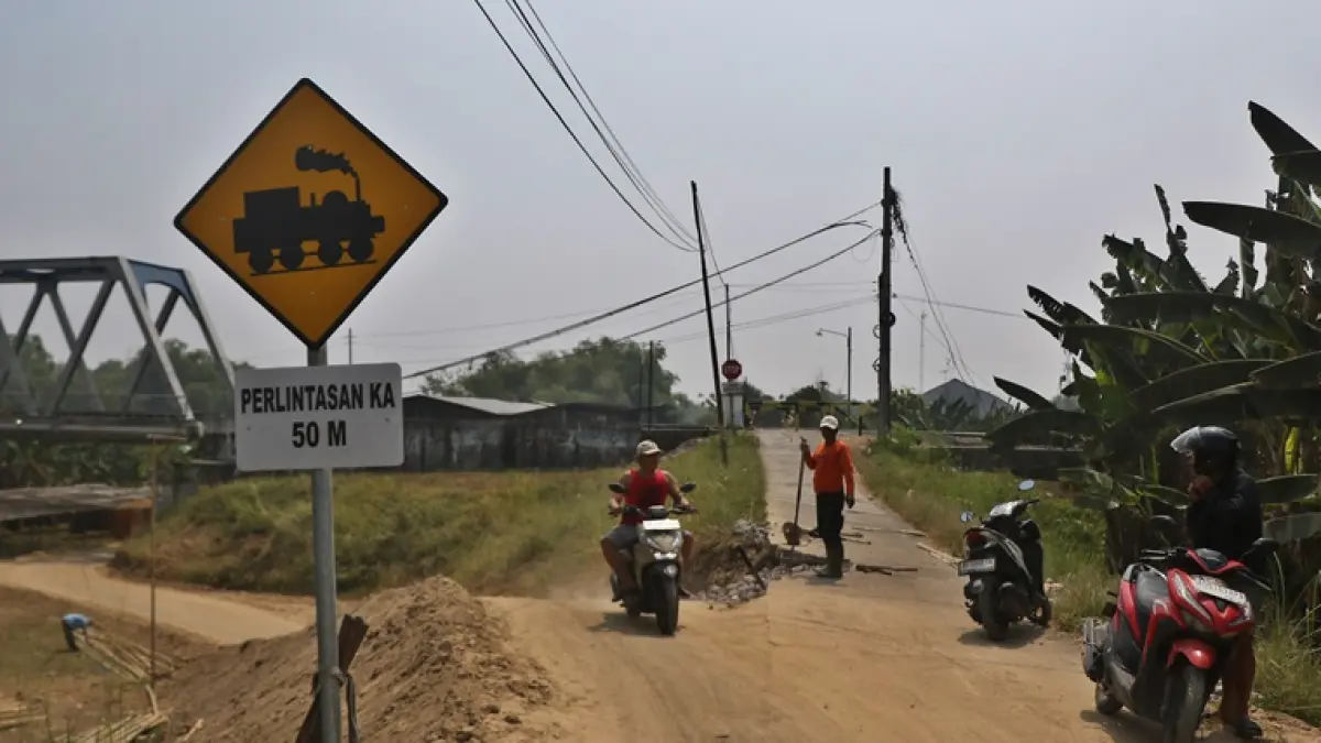 Warga melintasi jalur alternatif di bawah jembatan KA yang dibangun warga, dampak penutupan perlintasan sebidang KA di Gadingan, Mojolaban, Rabu (5/8). (ARIEF BUDIMAN/RADAR SOLO)
