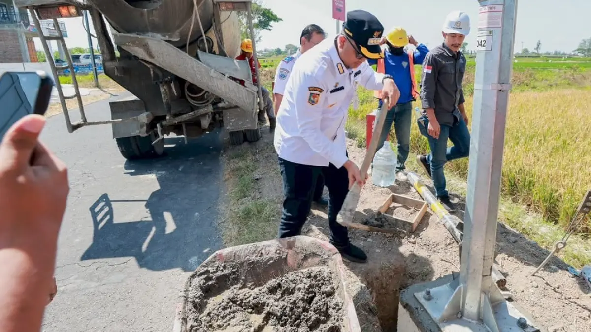 Bupati Klaten Hamewang Wajar Ismoyo membantu mengecor tiang lampu penerangan jalan umum di kawasan Jalan Nglinggi, Kecamatan Klaten Selatan, Rabu (5/8/2026). (Dokumentasi Bagian Prokopim Setda Klaten)
