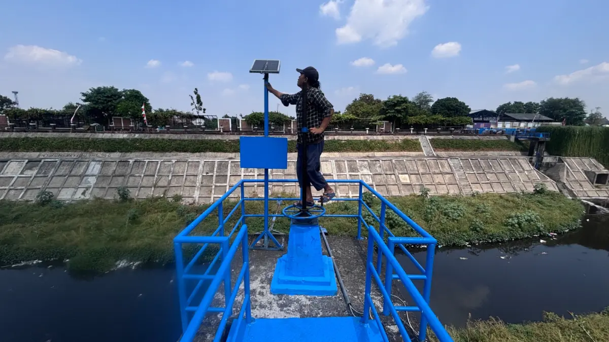 ANTISIPASI: Warga tengah mengecek panel surya yang ada di Bendungan Sangkrah, Kecamatan Pasar Kliwon. (ARIEF BUDIMAN/RADAR SOLO)