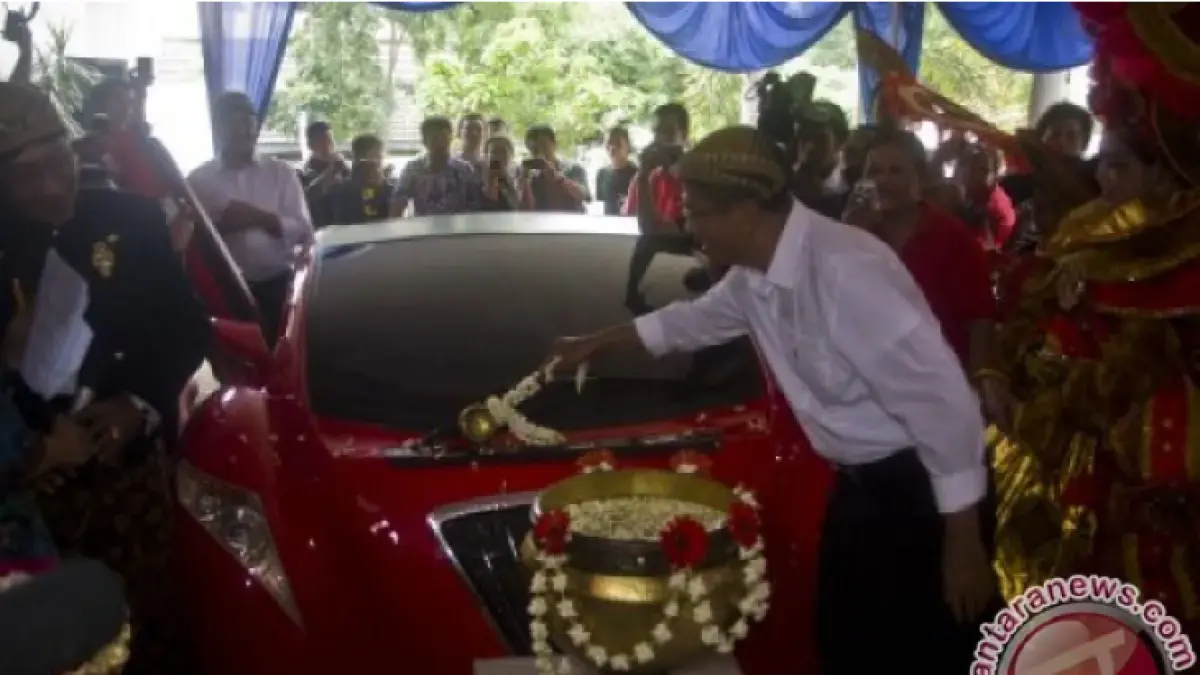 Dahlan Iskan, yang kala itu menjabat Menteri BUMN "memandikan" mobil listrik Tucuxi di halaman kantor Radar Solo, Jalan Kebangkitan Nasional, Sriwedari, Laweyan, Solo sebelum digunakan menuju Surabaya, Sabtu (5/1/2013. (Andika Betha/ANTARA)