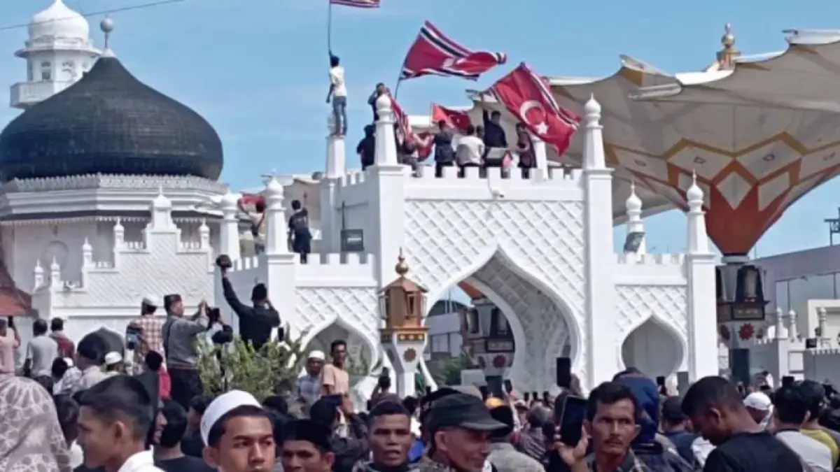 Sekelompok orang mengibarkan bendera bulan dan bintang di acara zikir dan doa bersama di Masjid Raya Baiturrahman, Banda Aceh, Sabtu (15/8/2026). ANTARA/M Haris SA.