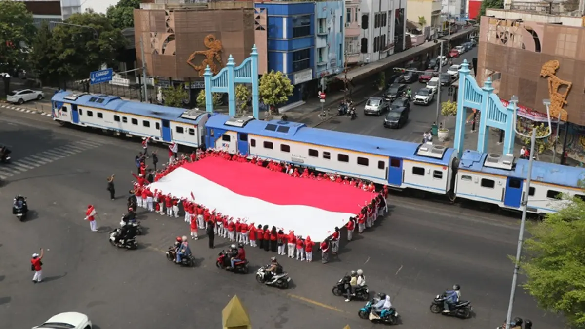 Warga membentengkan bendera raksasa merah putih di simpang Ngarsopuro, Jalan Slamet Riyadi Solo, pada peringatan detik-detik proklamasi, Senin (17/8). (ARIEF BUDIMAN/RADAR SOLO)
