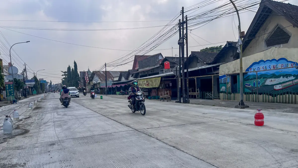 Pengguna jalan melintasi Jalan Adi Sumarmo, Kecamatan Kartasura, Sukoharjo yang progres pembangunannya sudah mencapai 90 persen. (M IHSAN/RADAR SOLO)