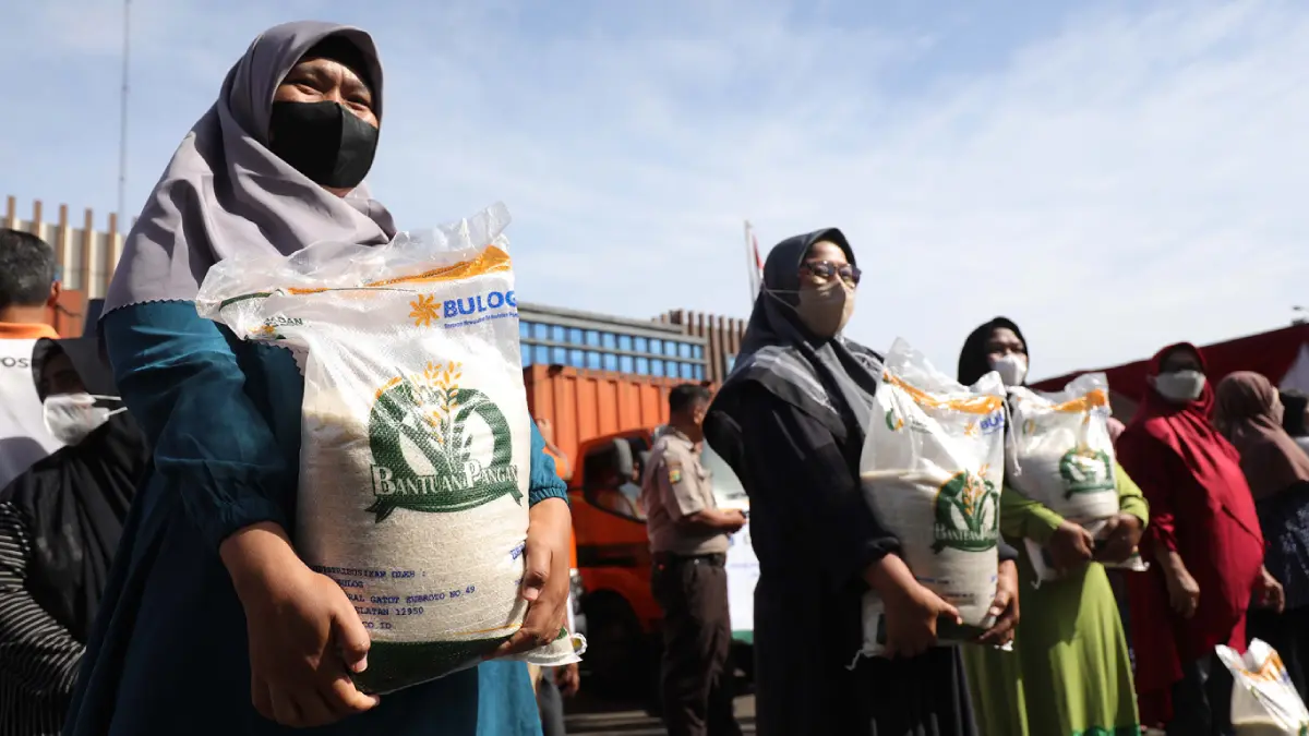 Warga menerima pencairan bansos beras. (JawaPos.com)