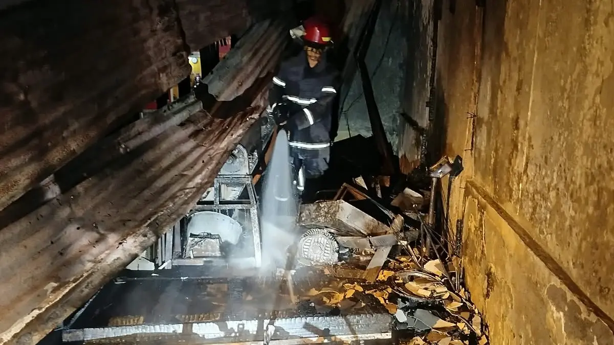 Petugas damkar memadamkan api yang membakar warung mi dan babi di Sukoharjo.