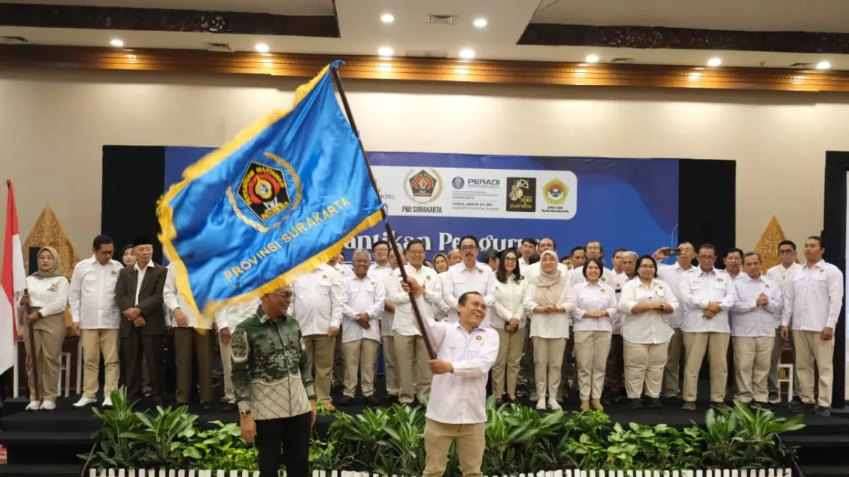 Sri Hartanto kibarkan panji setelah dilantik sebagai Ketua PWI Surakarta masa bakti 2026–2031 di The Sunan Hotel Solo, Sabtu (12/9/2026). (DOK.PWI SURAKARTA)