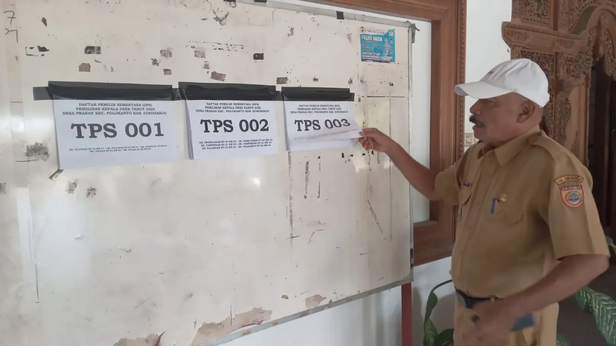 Kepala Desa Pranan Sardjanto tempelkan pengumuman DPS di balai desa setempat, Selasa (15/9). (IWAN KAWUL/RADAR SOLO)