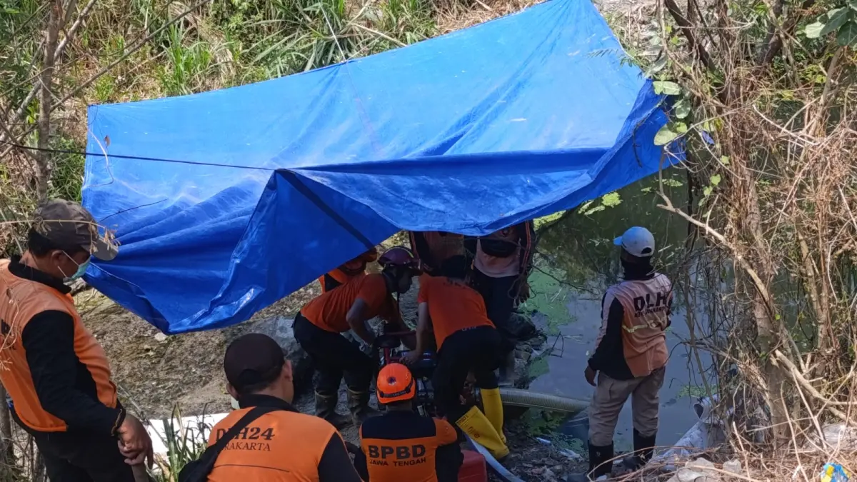 Petugas DLH Kota Solo ambil air sungai untuk membasahi gunungan sampah TPA Putri Cempo.