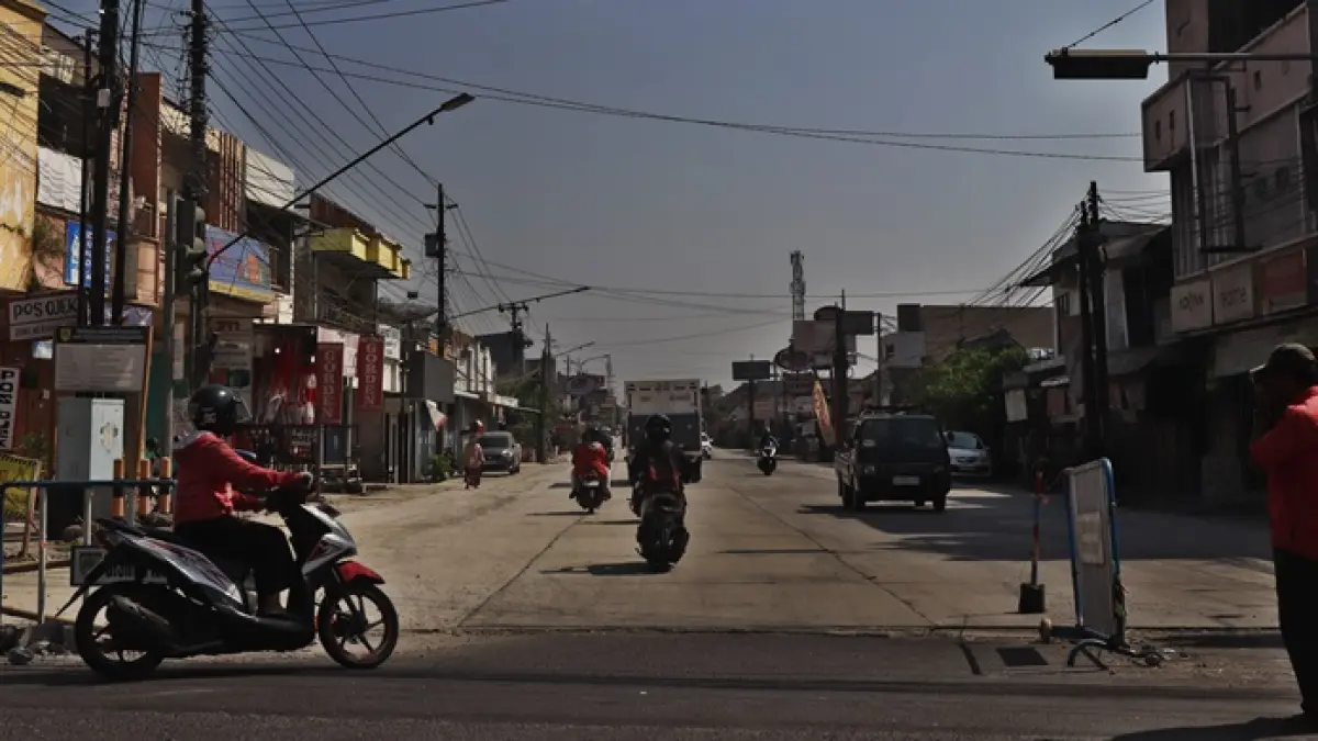 Pengendara sepeda motor dan mobil pribadi melintas di Jalan Adi Sumarmo, Kartasura, Sukoharjo yang pengerjaannya dikebut hingga Desember 2026. (KUMALA/RADAR SOLO)