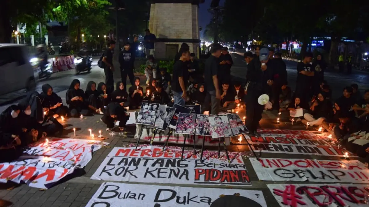 Aliansi BEM Solo Raya aksi damai dengan tabur bunga, menyalakan lilin, dan berdoa sembari bentangkan spanduk di Bundaran Gladak, Selasa malam (29/9). (ALFIDA NURCHOLISAH/RADAR SOLO)