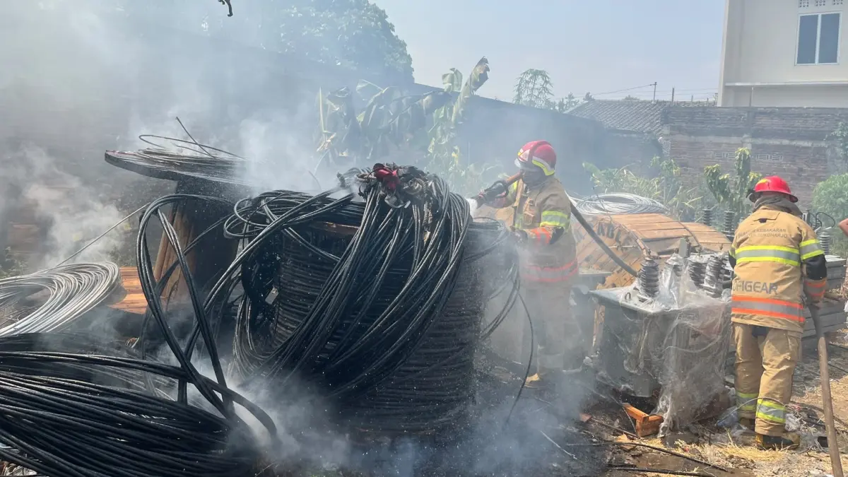 Petugas damkar padamkan api yang membakar kabel di belakang gudang milik PT Simpono di Kampung Sukoharjo RT 01 RW 03, Kamis (1/10). (IWAN KAWUL/RADAR SOLO)
