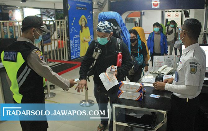 ATURAN BARU: Penumpang KA dicek suhu tubuh sebelum masuk Stasiun Solo Balapan.  (CITRA/RADAR SOLO)