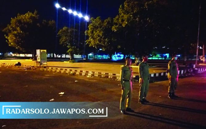 HALAU PEDAGANG: Personel Satpol PP berjaga di kawasan pelataran Alun-Alun Karanganyar, Minggu (21/3) pagi. (RUDI HARTONO/RADAR SOLO)