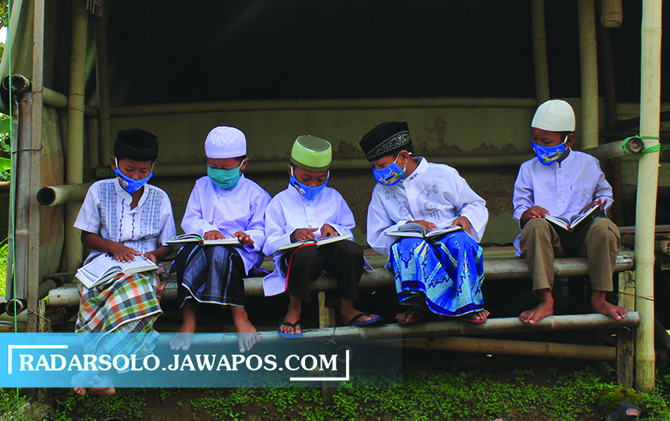 TERUS BELAJAR: Sejumlah santri TPA Nurul Huda Sabrang Lor RT 07 RW 08 Mojosongo, Jebres, membaca Alquran dengan tetap menerapkan prokes. (CITRA AYU/RADAR SOLO)