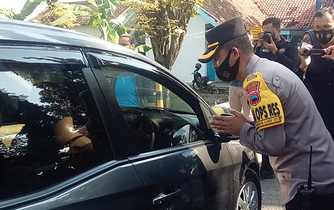 Petugas gabungan memeriksa kendaraan luar provinsi di pos Sambungmacan, Sragen, Selasa (20/4).