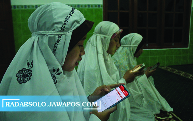 ERA DIGITALISASI: Jamaah membaca Alquran menggunakan smatrphone di Masjid Al-Wustho Boyolali. (CITRA AYU/RADAR SOLO)