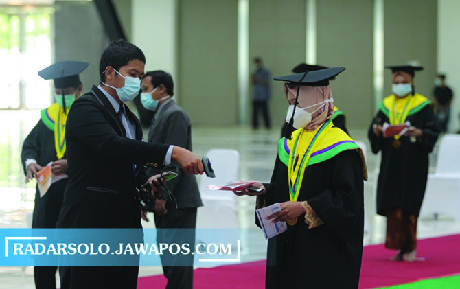 PROKES KETAT: Petugas mengecek berkas yang dibawa calon wisudawan Universitas Muhammadiyah Surakarta sebelum diwisuda di Edutorium UMS, Rabu. (RAGIL LISTIYO/RADAR SOLO)