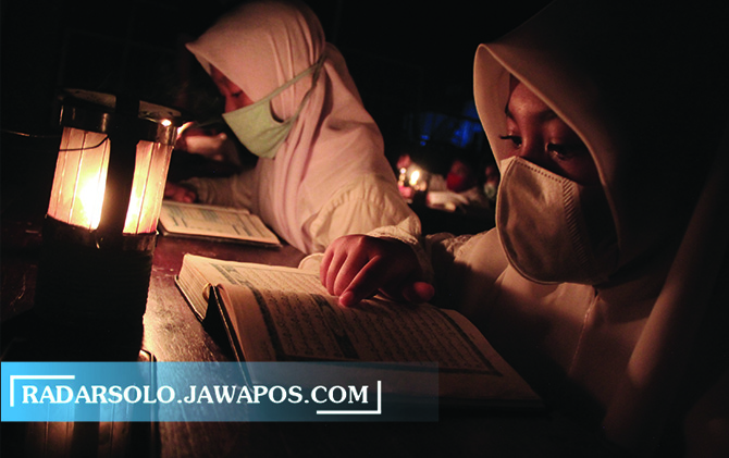 KHUSYUK: Santri Pondok Pesantren Baithul Musthofa menggelar pengajian di tengah temaram cahaya lilin di Kawasan Kelurahan Mojosongo, Kecamatan Jebres, Selasa (4/5) malam. (CITRA AYU/RADAR SOLO)