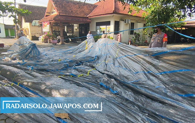 Polisi membentangkan balon udara yang jatuh di Desa Krecek, Banyudono, Minggu petang (30/5).