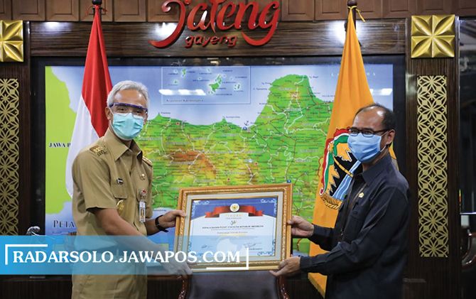 Gubernur Ganjar Pranowo menerima penghargaan dari Kepala BPS Jateng Sentot Bangun Widoyono, kemarin (13/7). (PEMPROV JATENG)