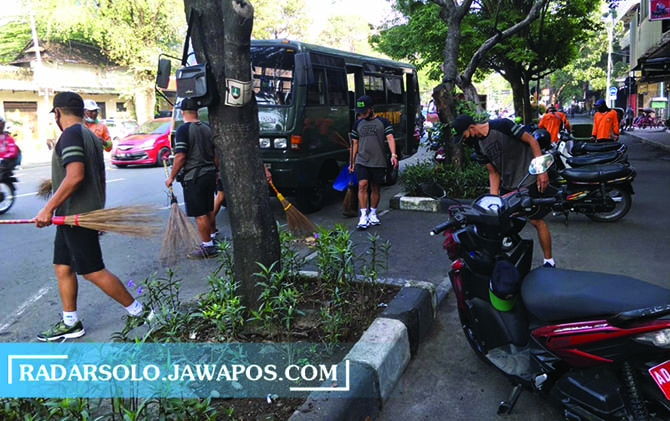 KERJASAMA: Dinas Lingkungan Hidup bersama TNI Polri dan ASN melakukan kerja bakti menyapu di sepanjang Jalan Slamet Riyadi, Jumat (18/6). Kegiatan ini digelar dalam rangka memperingati Hari Lingkungan Hidup Sedunia. (SILVESTER KURNIAWAN/RADAR SOLO)