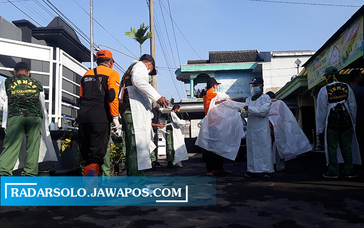 BUTUH DUKUNGAN: Linmas dan relawan dikerahkan melakukan penyemprotan disinfektan di Karangwuni, Polokarto belum lama ini. (IWAN KAWUL/RADAR SOLO)