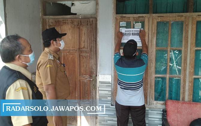 MUDAHKAN PENDATAAN: Lurah Gayam Havid Danang (tengah) dampingi tim tracer tempelkan pamflet di rumah warga yang menjalani isolasi mandiri belum lama ini. (IWAN ADI LUHUNG/RADAR SOLO)