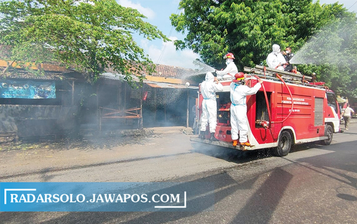 PUTUS RANTAI: Petugas Pemadam Kebakaran melakukan penyemprotan disinfektan di Pasar Simo Boyolali, Rabu (30/6). Kegiatan ini guna memutus rantai persebaran Covid-19. (RAGIL LISTYO/RADAR SOLO)