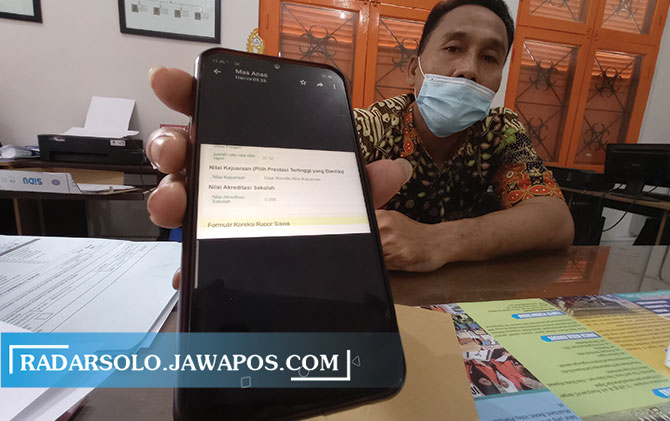 BELUM BERES: Petugas menunjukkan pendaftaran PPDB secara online dari handphone, kemarin (23/6). (SEPTINA FADYA/RADAR SOLO)