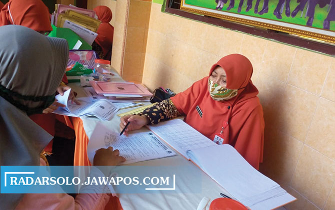 KERJA KERAS: Guru SMP Muhammadiyah 8 Surakarta melayani PPDB sebelum diberlakukan PPKM darurat. (MANNISA ELFIRA/RADAR SOLO)