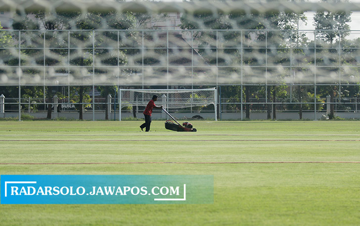 TERAWAT: Pekerja sibuk memotong rumput lapangan Kota Barat, kemarin (15/7). Lapangan Kota Barat merupakan salah satu venue pendukung Piala Dunia U-20. (IHSAN/RADAR SOLO)