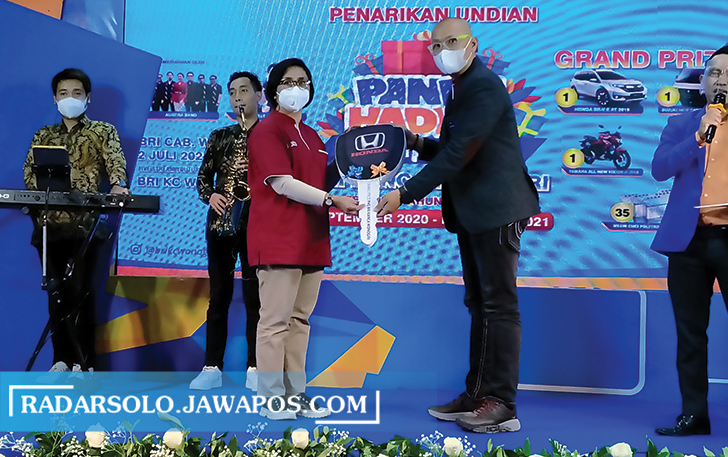 TETAP MERIAH: Pemimpin Cabang BRI Wonogiri Agung Ari Wibowo (kanan) secara simbolis memberikan replika kunci kepada perwakilan BRI Unit Wonogiri yang mewakili nasabah pemenang grandprize.  (IWAN ADI LUHUNG/RADAR SOLO)
