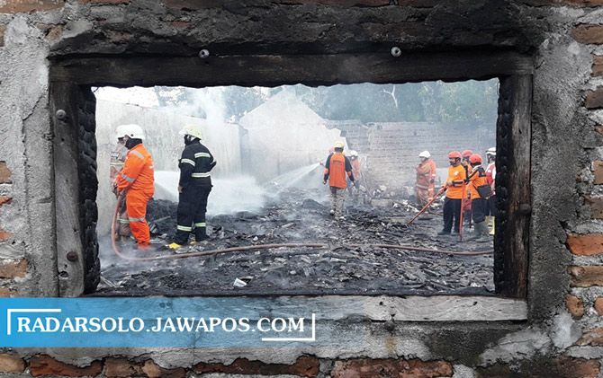 Petugas damkar melakukan proses pendinginan dalam kejadian kebakaran gudang plastik di Sroyo, Jaten, Karanganyar, Rabu (23/9) siang.&nbsp;