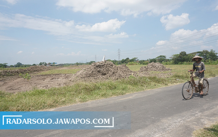 PROYEK STRATEGIS: Warga melintas di proyek Jalan Tol Solo-Jogja di Desa Kuncen, Kecamatan Ceper, kemarin. (ANGGA PURENDA/RADAR SOLO)