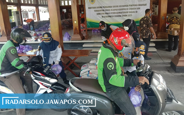 DRIVE THRU: Penyaluran bantuan sembako ke ojol dan seniman, kemarin. (AHMAD KHAIRUDIN/RADAR SOLO)