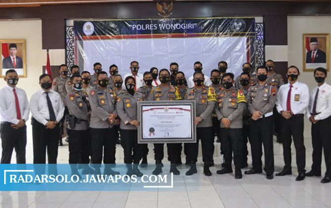 Kapolres Wonogiri AKBP Christian Tobing (tengah) bersama petinggi dan anggota lain menunjukkan penghargaan predikat Wilayah Bebas Korupsi dari Kemenpan-RB di Aula Polres Wonogiri, Senin (21/12).