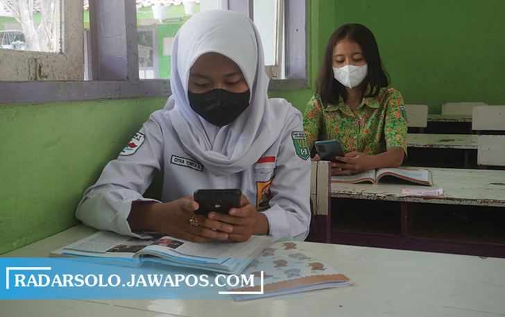 FOKUS: Siswa di SMPN 1 Jogonalan mengikuti pembelajaran secara daring dengan memanfaatkan fasilitas internet sekolah dengan handphone masing-masing. (ANGGA PURENDA/RADAR SOLO)