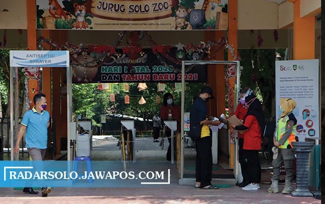 PROKES KETAT: Pengunjung TSTJ diperiksa suhu tubuhnya sebelum masuk kawasan wisata. (RADAR SOLO PHOTO)