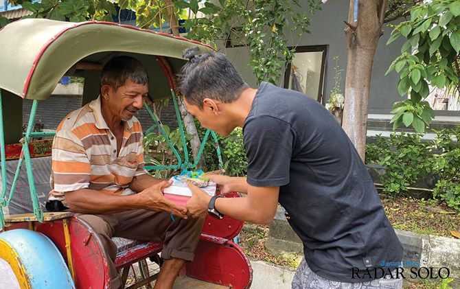 Member Zetizen Solo membagikan nasi kotak kepada tukang becak di Solo.