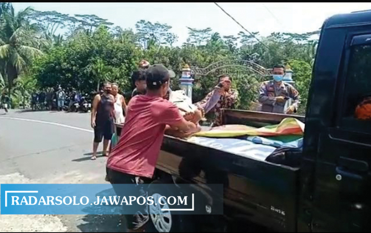 Polisi dan warga mengevakuasi korban kecelakaan maut di jalan Karanganyar-Jatipuro, Selasa (28/9) siang. (RUDI H/RADAR SOLO)