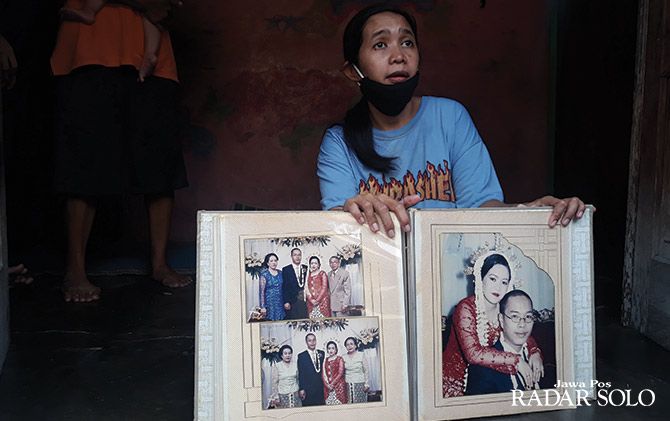 Tri Susanti saat memperlihatkan foto bersama suaminya saat menikah.