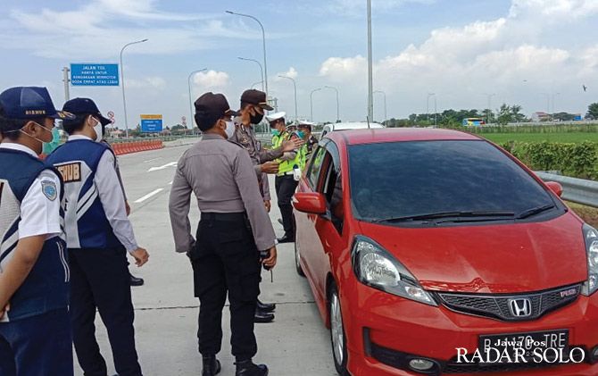 Polisi dan petugas gabungan memeriksa kendaraan berplat luar kota di pintu tol Pungkruk, Sragen, Minggu (26/4).