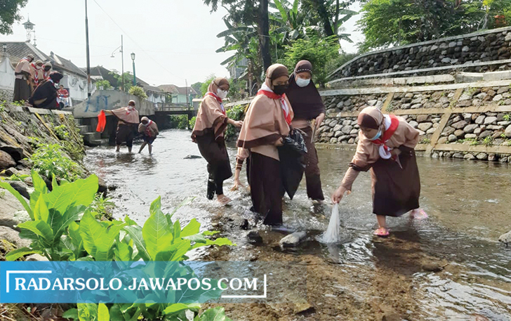BELAJAR PEDULI SUNGAI: Sejumlah siswa SD di Guyangan dilibatkan dalam aksi bersih-bersih Sungai Guyangan, Jumat (24/9). Aksi ini digelar dalam memperingat  World Clean Up Day (WCD). (RAGIL LISTIYO/RADAR SOLO)