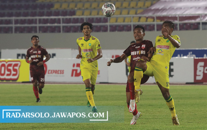 REGULASI KETAT: Striker Persis Solo Ferdinand Sinaga (tengah) dikepung pemain Hizbul Wathan FC di Stadion Manahan dengan latar belakang tribun tanpa penonton, Senin (18/10) kemarin. (M. IHSAN/RADAR SOLO)