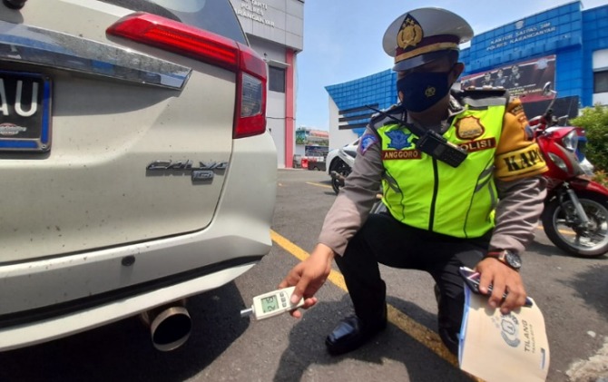 KBO Satlantas Polres Karanganyar Iptu Anggoro Wahyu saat melakukan pengecekan tekanan suara pada knalpot Toyota Calya milik warga Jumantono. (RUDI H/RADAR SOLO)