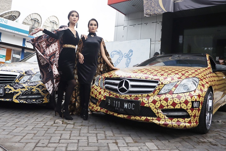 KEREN: Sejumlah model berpose di depan Mercedes-Benz milik anggota MOC Indonesia Solo yang dibalut motif batik dan dipamerkan di halaman kantor Jawa Pos Radar Solo, Sabtu (2/10). (M.IHSAN/RADAR SOLO)