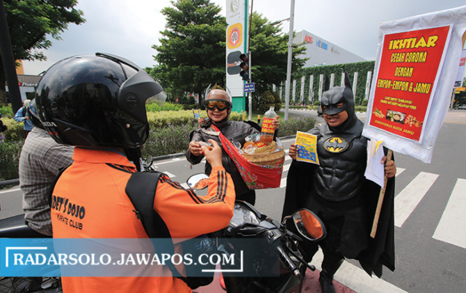 Superhero bagi empon-empon kepada pengguna jalan, beberapa waktu lalu. (RADAR SOLO PHOTO)